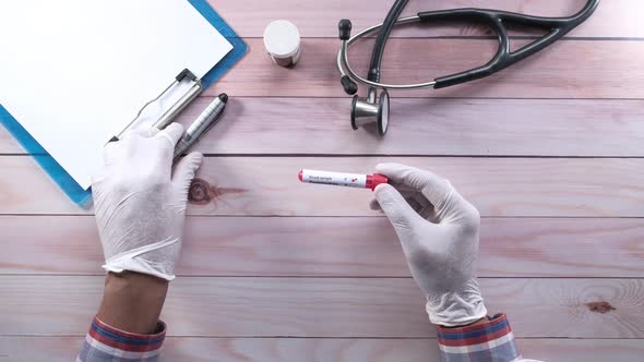 Top View of Laboratory Technician Analyzing Blood Test Tube 