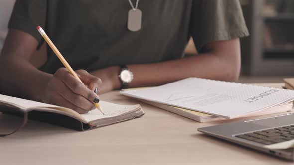 Military Woman Planning Budget while Working from Home alt