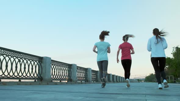 Slow Motion Shot of the Legs of Three Girls Friends Morning Run