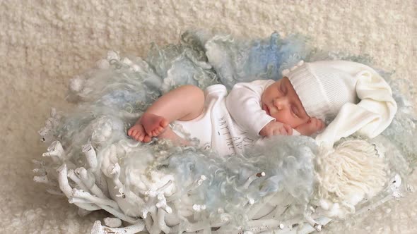 Little Newborn Baby Girl Is Lying on the Bed Wrapped in Blanket