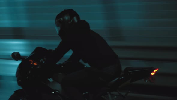 A Man Rides a Sports Motorcycle Through the City at Night