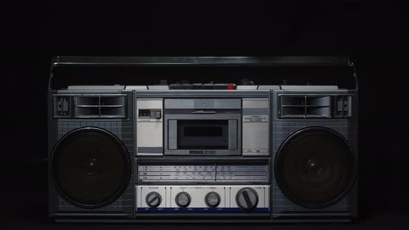 A Man's Hand with a Finger Presses the Play Button on an Old Vintage Gray Cassette Tape Recorder