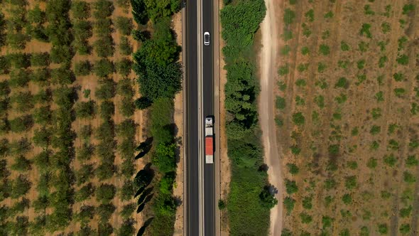 Truck loaded with Shipping Container driving on a rural highway, Aerial follow footage.