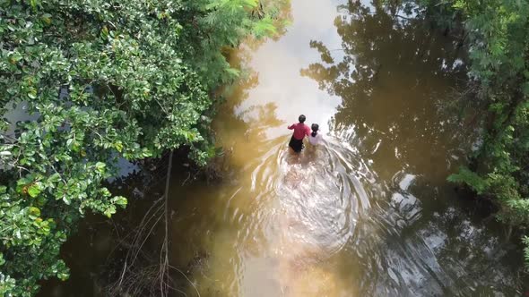 Lonely family Struggling Through A Flooded Street Caused By Heavy Rainfall in Cambodia.Aerial slow m