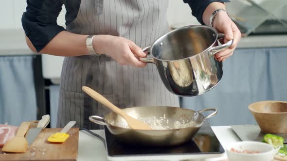 Crop woman cooking risotto in pan in kitchen