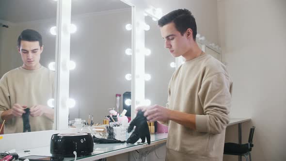 An Attractive Man Makeup Artist Brings His Instruments to the Table in Backstage Room and Putting on