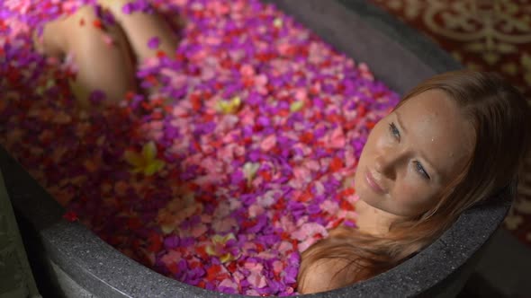 Slowmotion Shot of a Beautiful Young Woman Taking a Floral Bath in a Tropical Spa