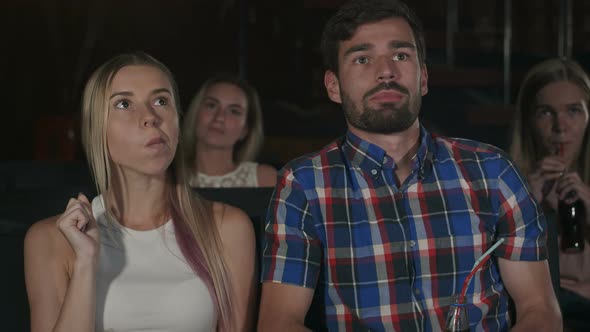 Happy Couple Sitting in Movie Theater, Eating Popcorn, Smiling