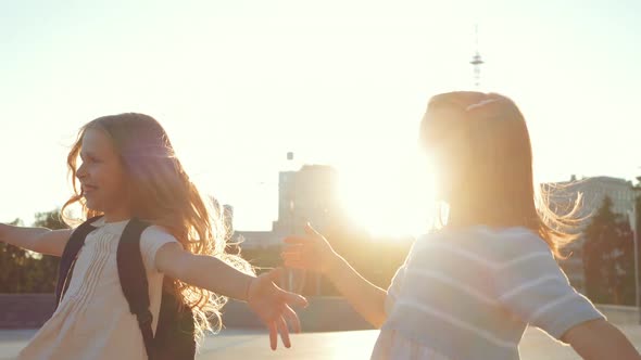 Two Little Girls Run Down Street To Female Teacher in Black, Three People Happily Hugging. Children