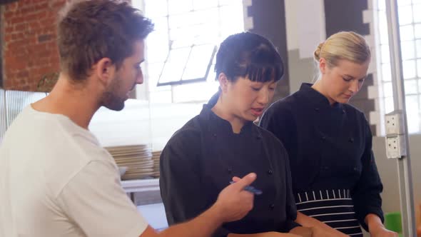 Manager giving order to chef in commercial kitchen 4k