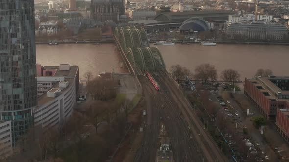 AERIAL: Train Crossing Cologne Hohenzollern Bridge on Sunny Day with Haze in the Sky 