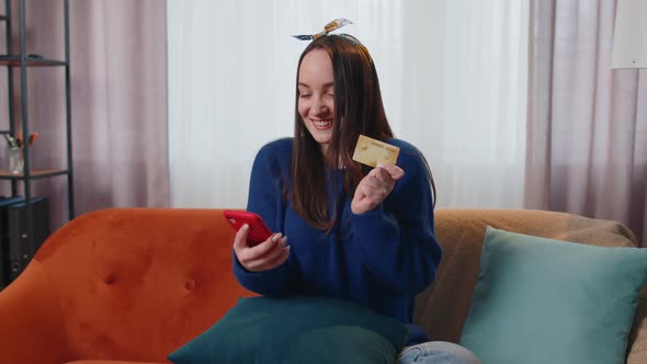 Woman Sitting at Home Using Credit Bank Card and Smartphone While Transferring Money Online Shopping