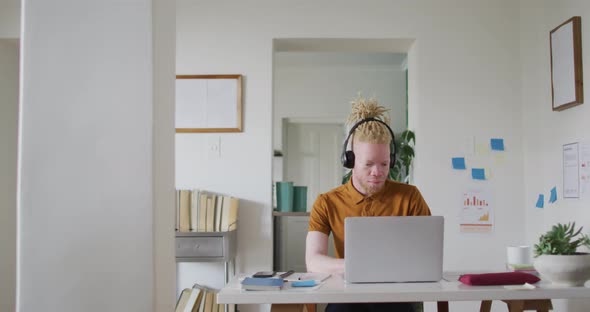 Albino african american man with dreadlocks making video call on the laptop