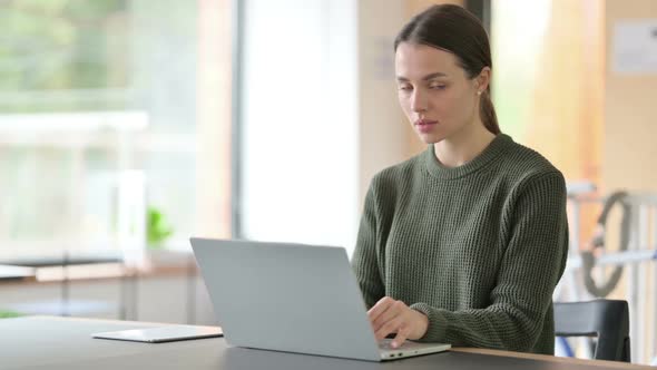 Young Woman with Laptop Smiling at the Camera