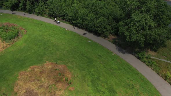 Two bicycle riders riding up a hill, with a top down view, tracing theirements in Bush Terminal Park
