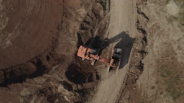 Top View of Excavator Loading the Truck with Clay at Open Pit