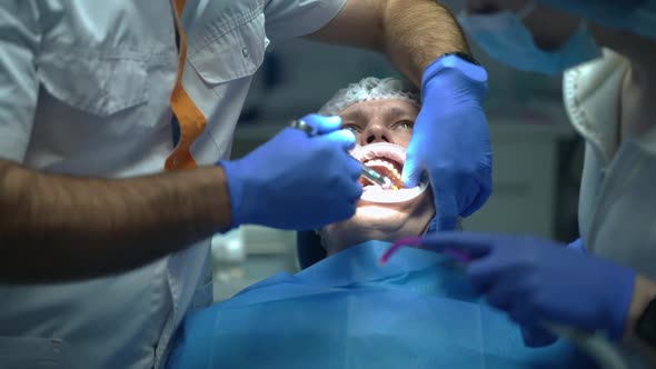 Live Camera Follows Dentist Injecting Anesthesia for Patient in Dental Chair Turning in Slow Motion