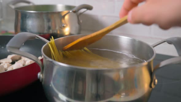 Cooking Spaghetti in Boiling Water Cooker on a Kitchen