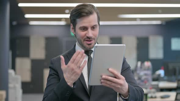 Portrait of Video Call on Tablet By Businessman in Office
