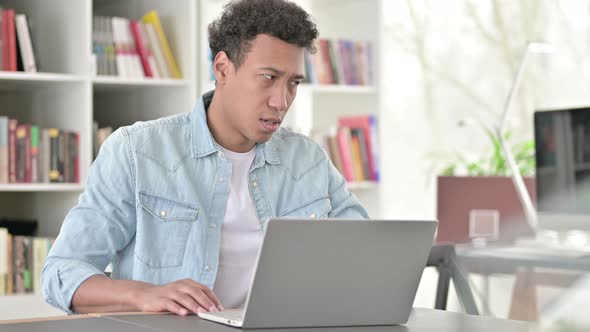 Exhausted Young African American Man Having Back Pain at Work 