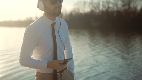 Cheerful Man Relaxing True Wireless Headphones Listening Music From Smartphone Streaming App.