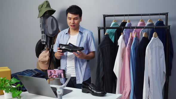 man selling shoes and clothes online by smartphone live streaming, business online