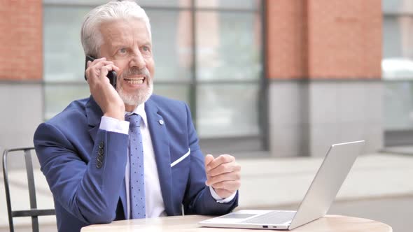 Angry Old Businessman Talking on Phone