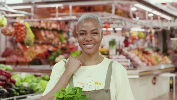 Slow motion shot of smiling woman with shopping bag in a market hall