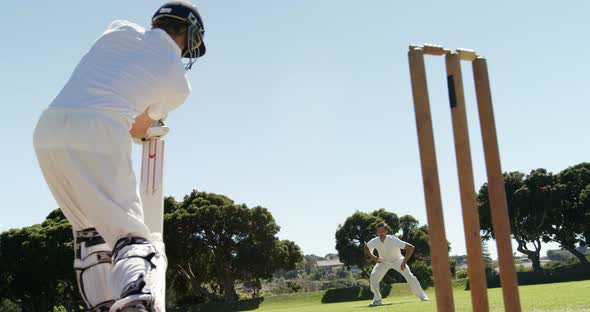 Batsman playing a defensive stroke during cricket match