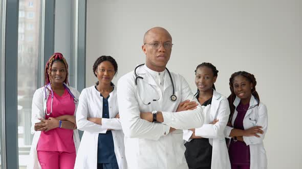 A Team of Doctors African American Man and Women Stand in Front of the Camera and Look Straight