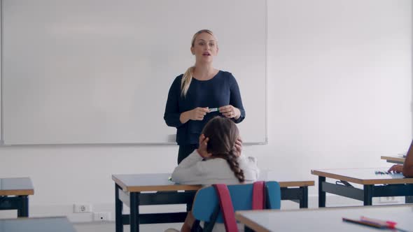 Primary School Teacher Writing on Empty White Board