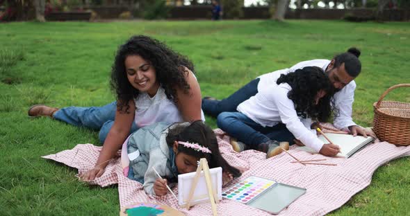Indian parents having fun at city park painting with their children