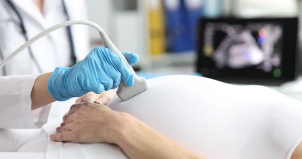 Doctor Making Ultrasound of Fetus to Pregnant Woman Patient in Clinic Closeup  Movie Slow Motion