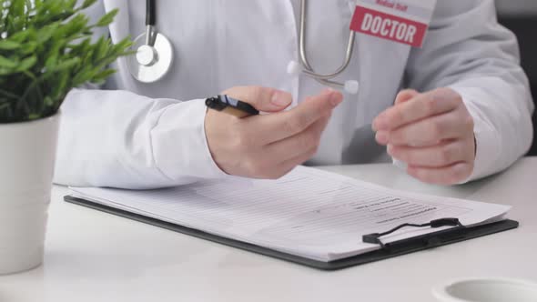 Doctor Hands Fingers Pushing Pen Preparing Writing Filling Papers in Office Room