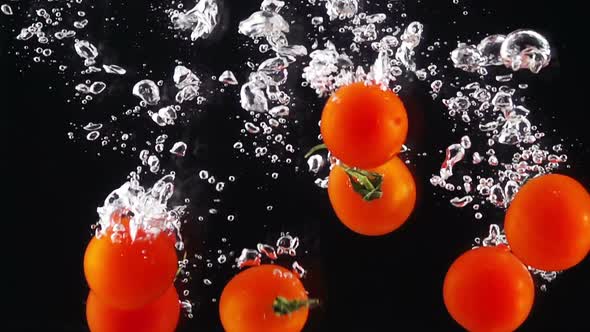 Whole Tomatoes Falling Through Water
