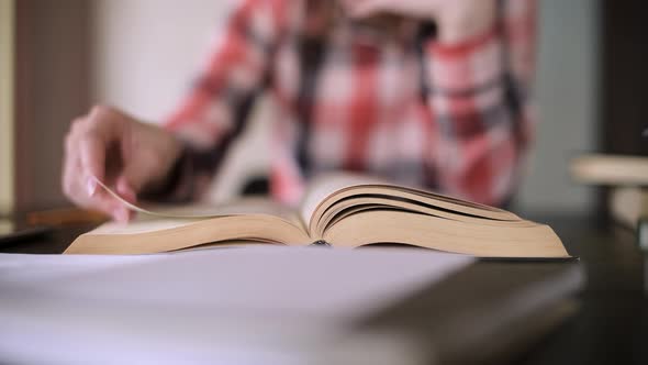 Girl leafing through a book. Close-up of pages from the end, selective focus