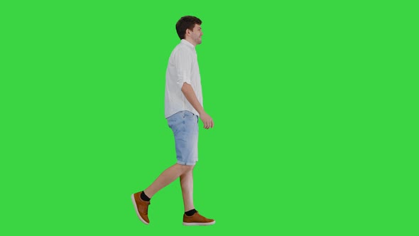 Casual Young Man Walking and Looking Forward on a Green Screen, Chroma Key.