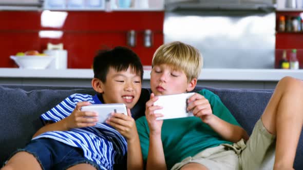 Siblings using mobile phone in living room