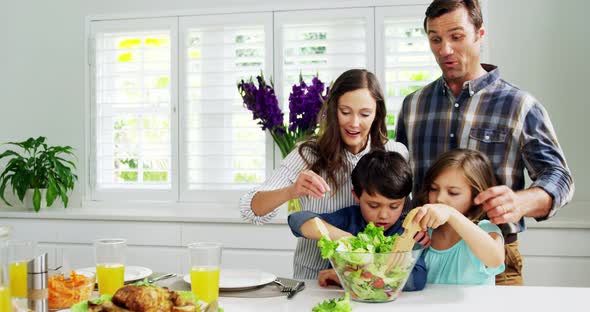 Happy family preparing vegetable salad