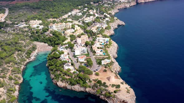Seaside town of Torrent de Cala Pi with beach inlet near by on Mallorca Spain, Aerial dolly out shot