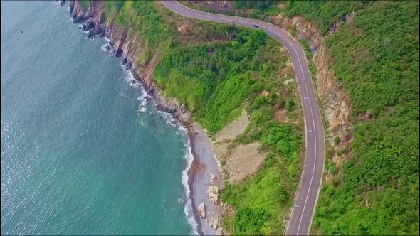 Close Aerial View of Coast Highway Along Azure Ocean