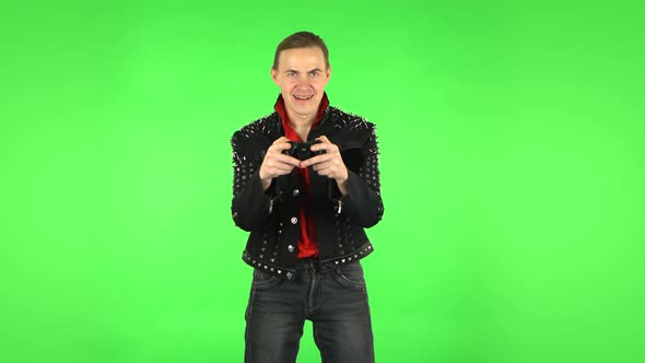 Guy Playing a Video Game Using a Wireless Controller and Rejoicing in Victory. Green Screen