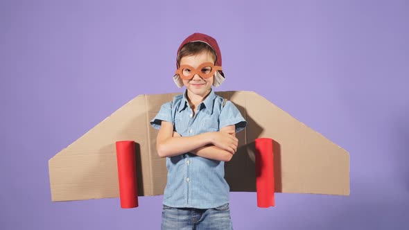 Studio Footage of a Young Pilot Flying on a Yellow Cardboard Plane Shows His Thumbs Up