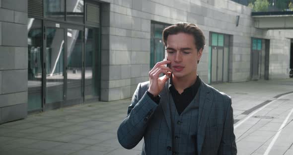 Young Business Man in Formal Suit Talking Phone While Walking at Downtown in Business District