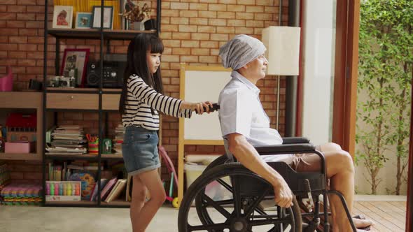 Old senior Asian man sitting in wheel chair in nusing home looking out of window