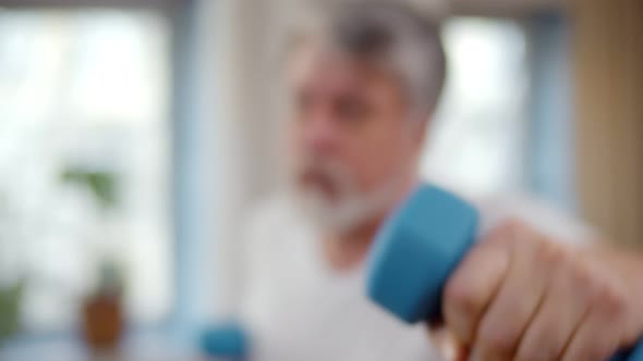 Senior Man Doing Sports in Living Room Using Dumbbells