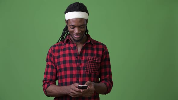 Young Handsome African Man with Dreadlocks Against Green Background