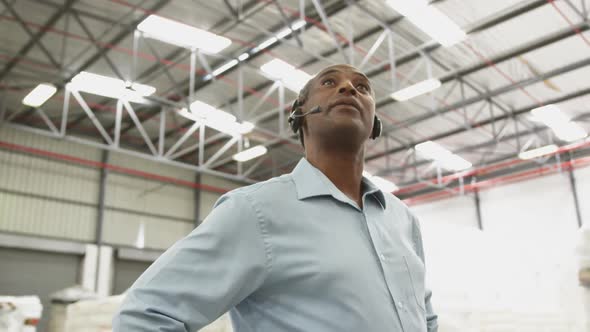 Close up of a male warehouse worker using headset in a storeroom 4k