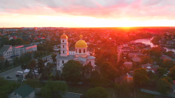 Small Church at the Bright Cloudy Sunset Filmed By Drone in Small European City. Kyiv Region