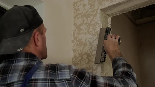 Close Up View of Worker Puts Decorative Plaster on the Wall Forming a Relief